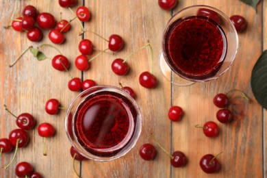 Photo of Delicious cherry wine with ripe juicy berries on wooden table, flat lay