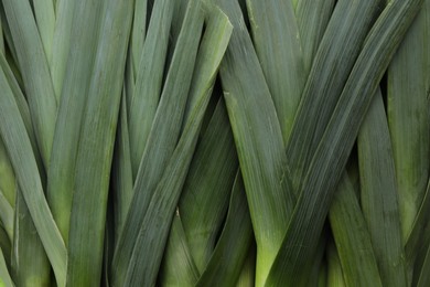 Fresh raw leeks as background, top view