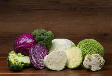 Photo of Different types of cabbage on wooden table