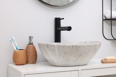 Photo of Different bath accessories and personal care products near sink on bathroom vanity