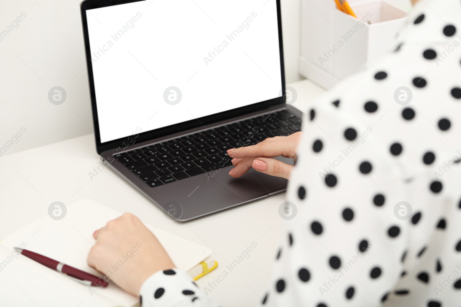 Photo of E-learning. Woman using laptop during online lesson at table indoors, closeup