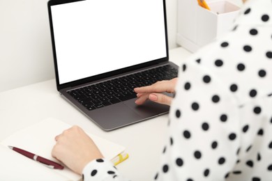 E-learning. Woman using laptop during online lesson at table indoors, closeup
