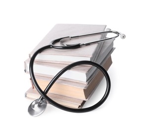 Photo of Stack of student textbooks and stethoscope on white background. Medical education