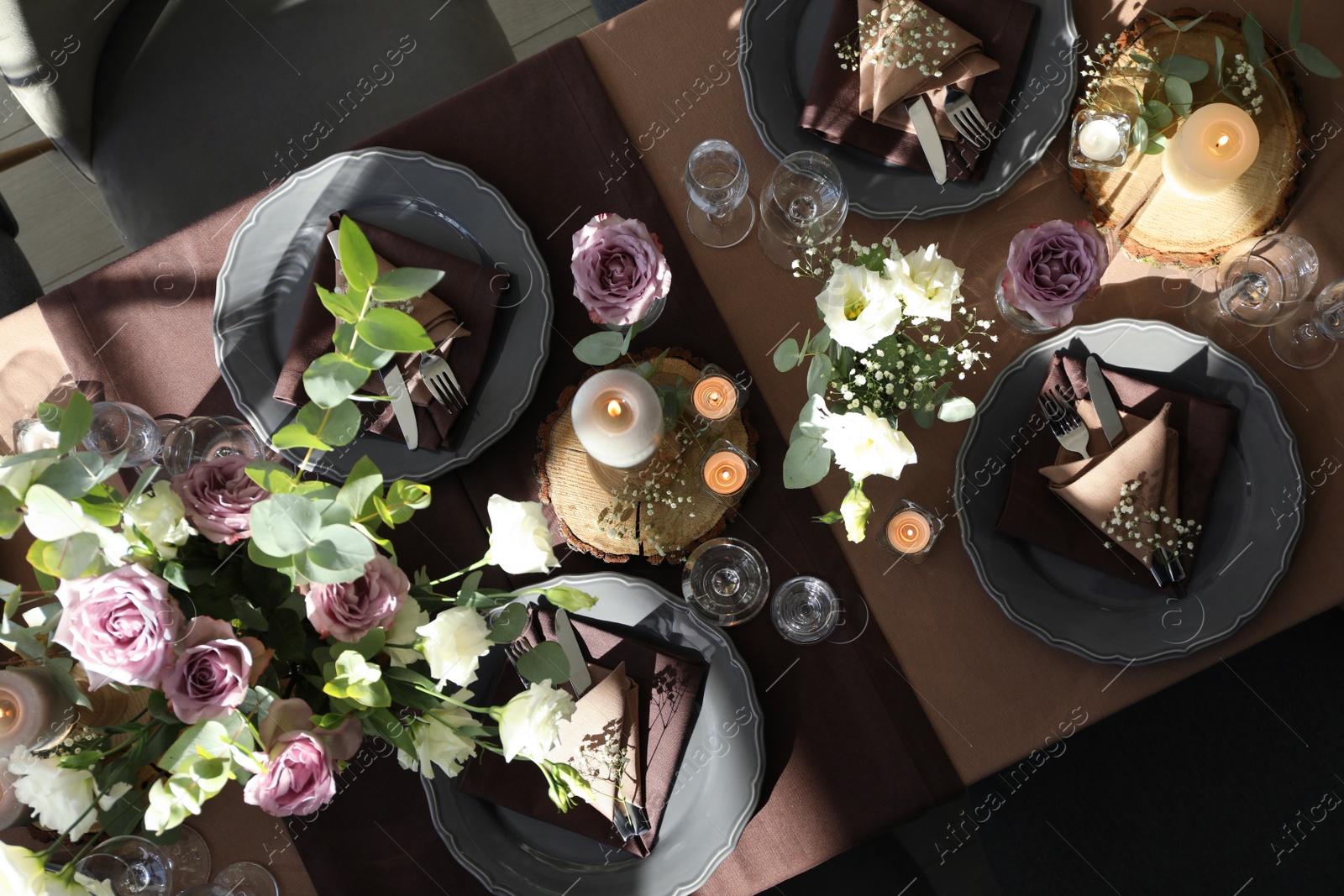 Photo of Festive table setting with beautiful tableware, candles and floral decor indoors, top view