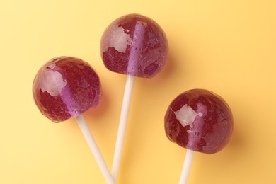 Tasty lollipops on yellow background, flat lay