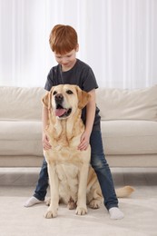 Photo of Cute child with his Labrador Retriever at home. Adorable pet