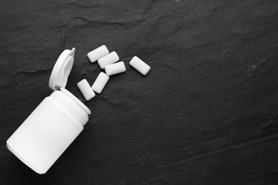 Photo of Jar with chewing gums on black table, flat lay. Space for text