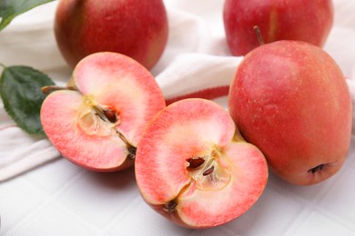 Photo of Tasty apples with red pulp on white tiled table, closeup