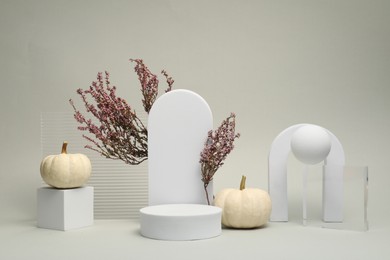 Autumn presentation for product. Geometric figures, pumpkins and heather flowers on light grey background