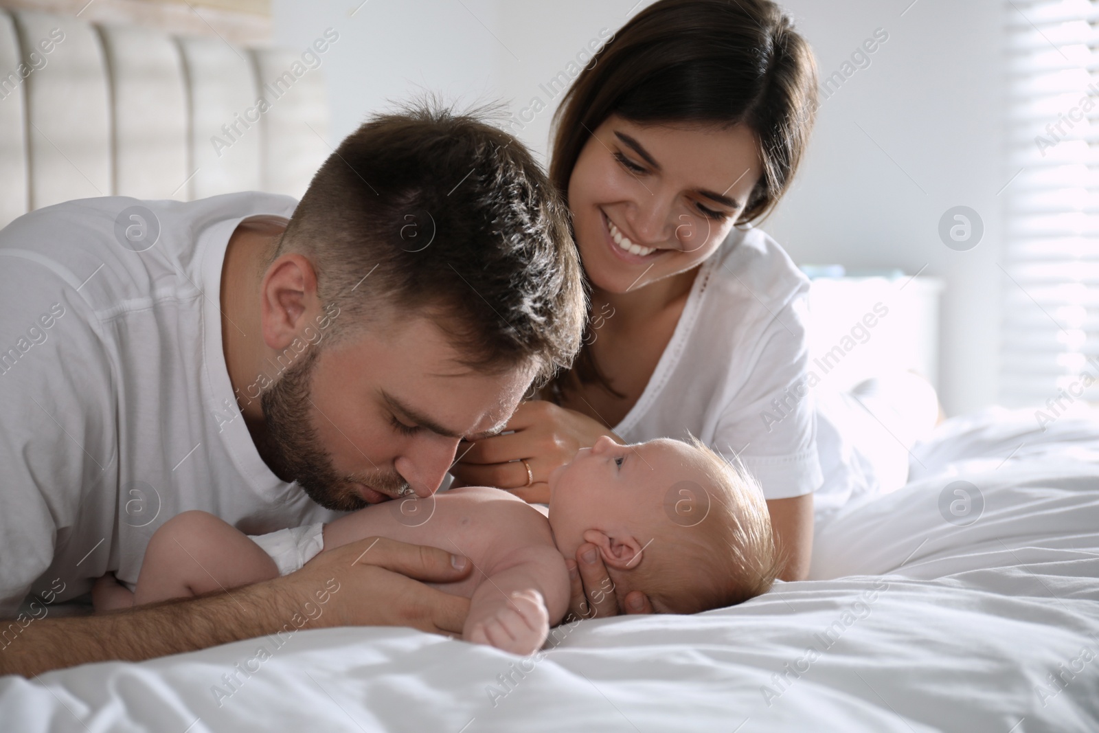 Photo of Happy couple with their newborn baby at home