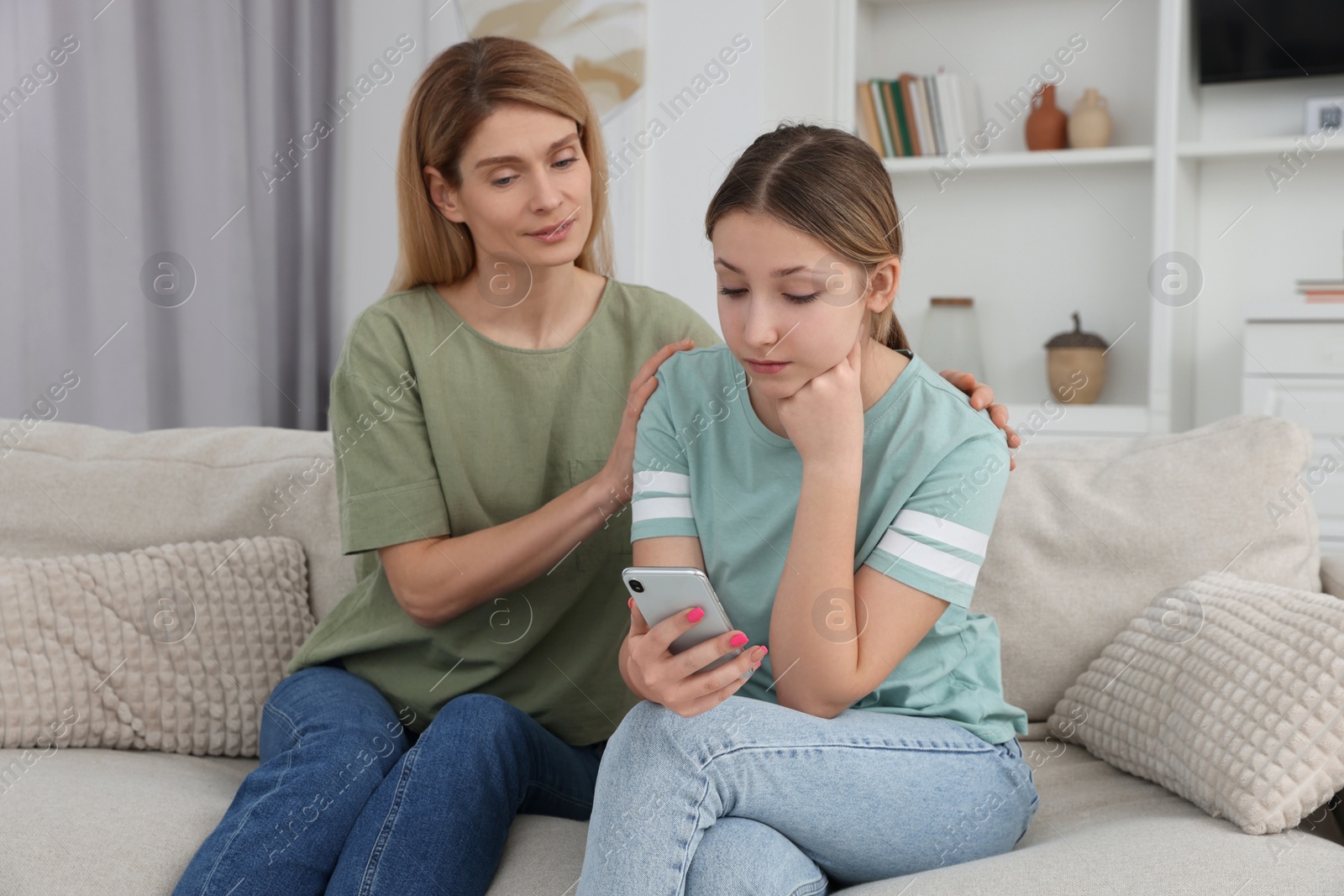 Photo of Mother comforting her upset teen daughter at home