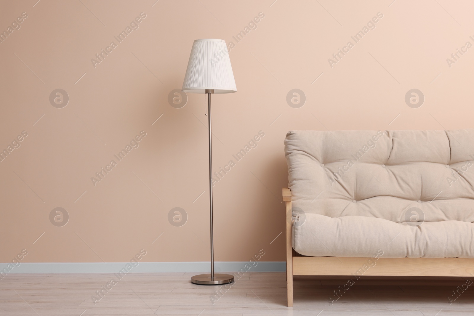 Photo of Comfortable sofa and stylish lamp indoors. Space for text