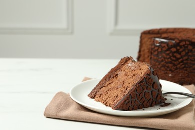 Photo of Piece of delicious chocolate truffle cake on white table, space for text