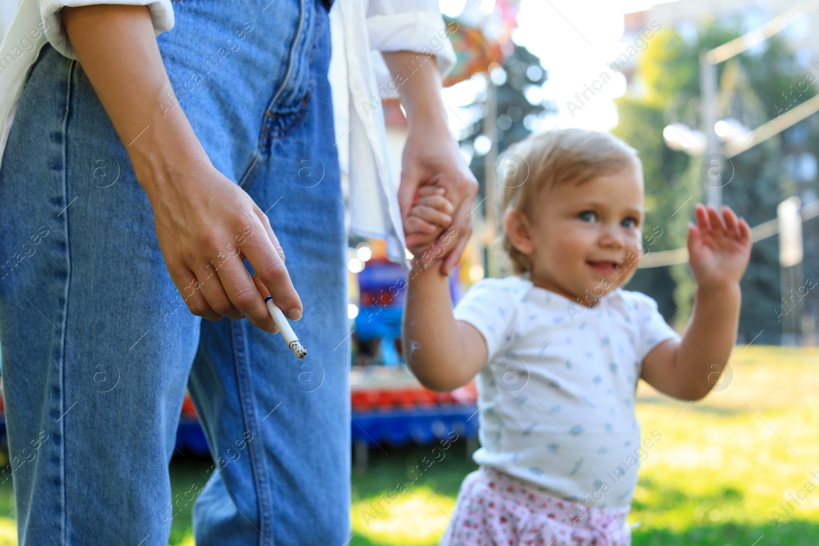 Photo of Mother with cigarette and child outdoors, closeup. Don't smoke near kids