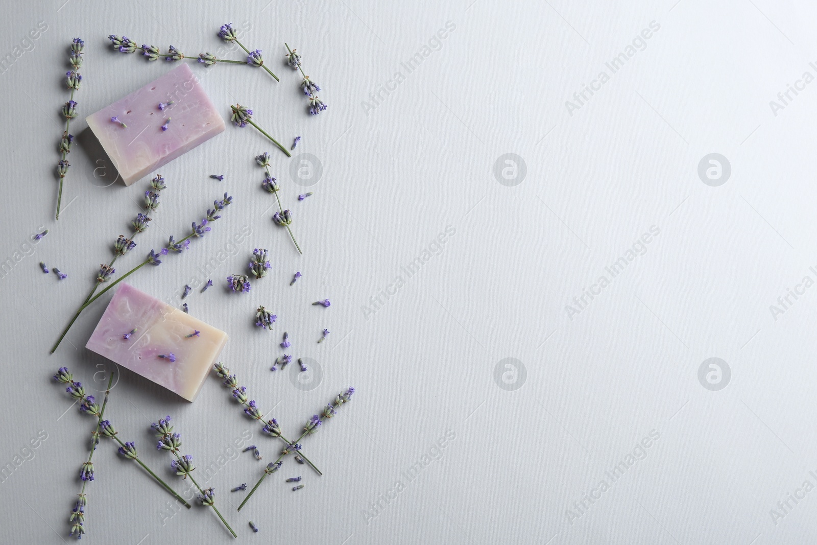 Photo of Hand made soap bars with lavender flowers on white background, top view