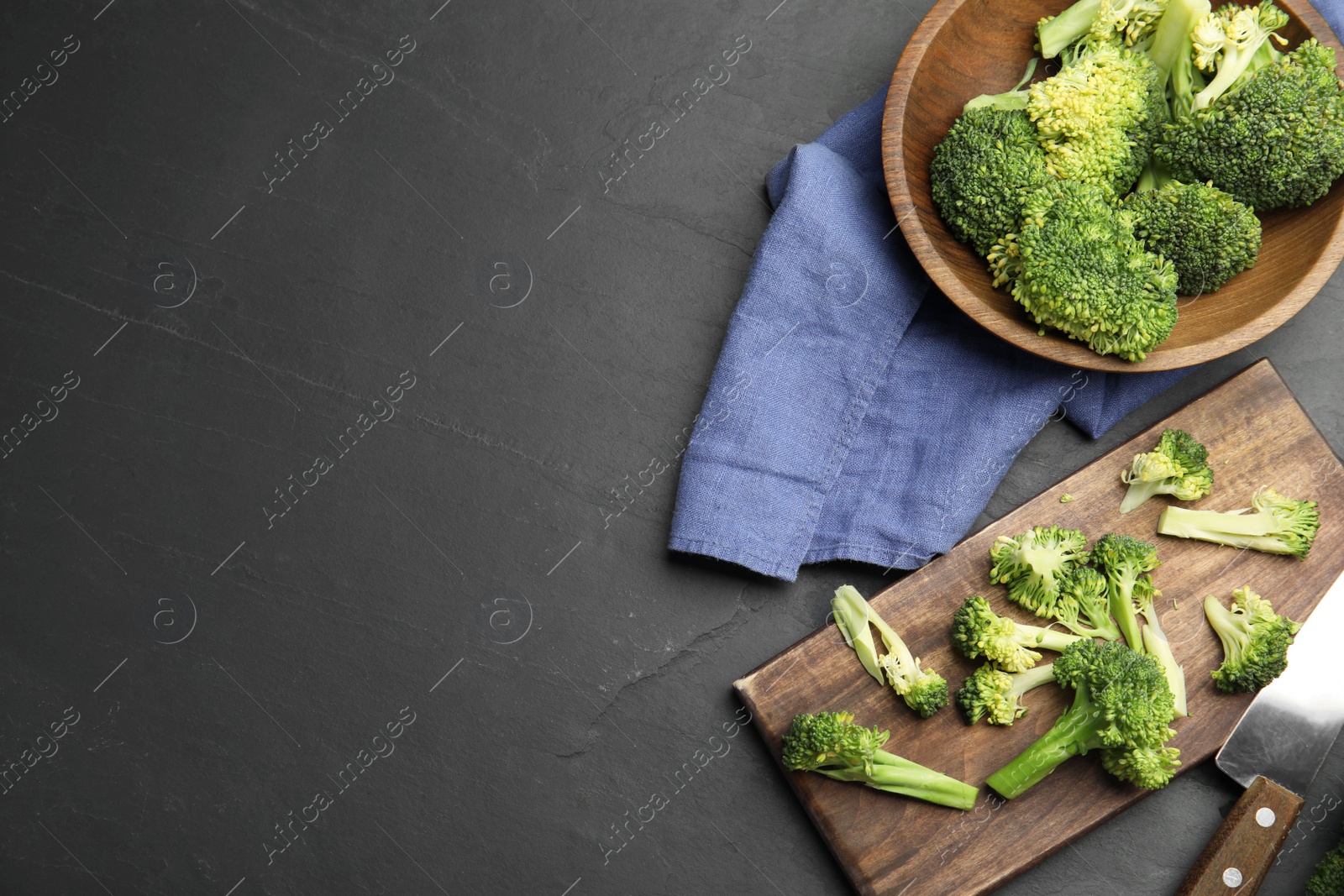 Photo of Flat lay composition with fresh broccoli on black table. Space for text