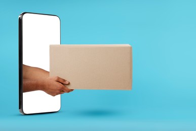 Courier passing parcel through smartphone on light blue background. Delivery service