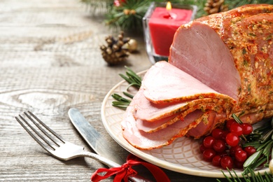 Plate with delicious ham served on wooden table, space for text. Christmas dinner