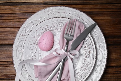 Festive table setting with painted egg and cutlery, top view. Easter celebration