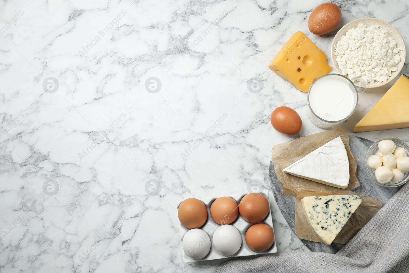 Photo of Different dairy products on marble table, flat lay. Space for text