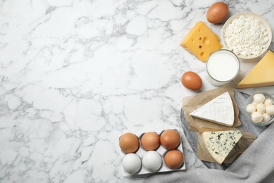 Different dairy products on marble table, flat lay. Space for text