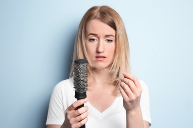 Photo of Young woman with hair loss problem on color background