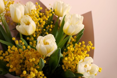 Bouquet of beautiful spring flowers near beige wall, closeup