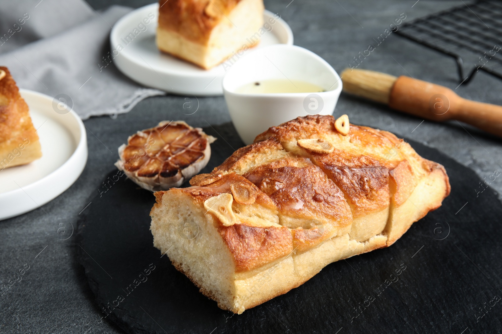 Photo of Slate plate with homemade garlic bread on table