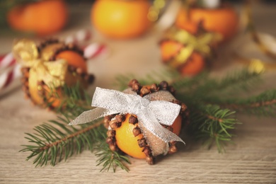 Pomander ball made of fresh tangerine and cloves on wooden table