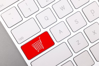 Image of Internet store. Red button with shopping cart on computer keyboard, top view