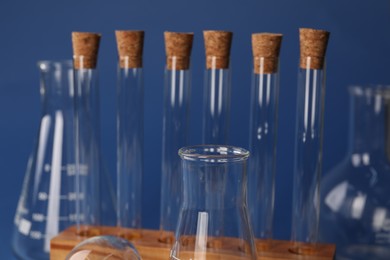 Photo of Different laboratory glassware on blue background, closeup