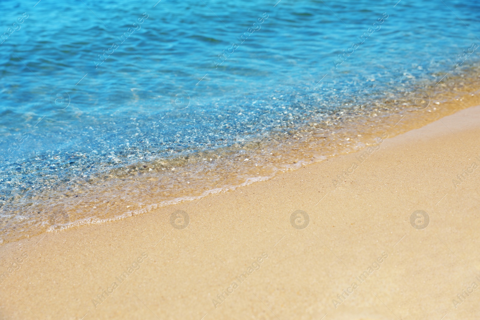 Photo of View of sea water and beach sand on sunny day