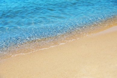 Photo of View of sea water and beach sand on sunny day