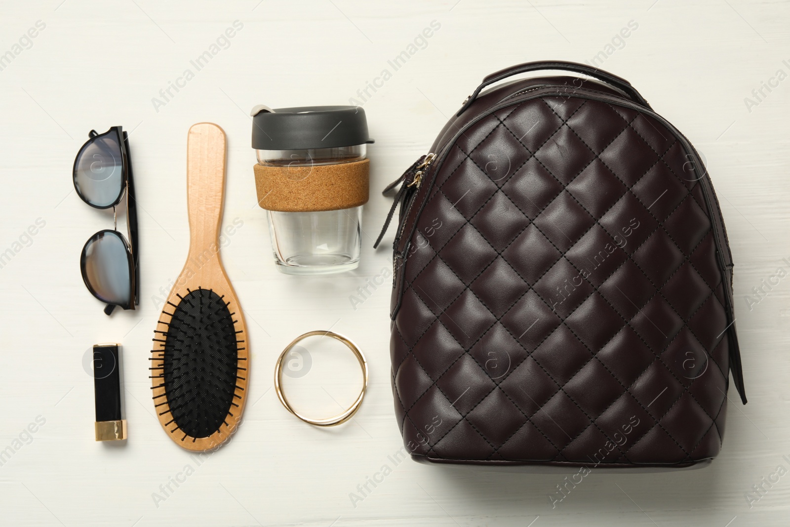 Photo of Stylish urban backpack with different items on white wooden background, flat lay