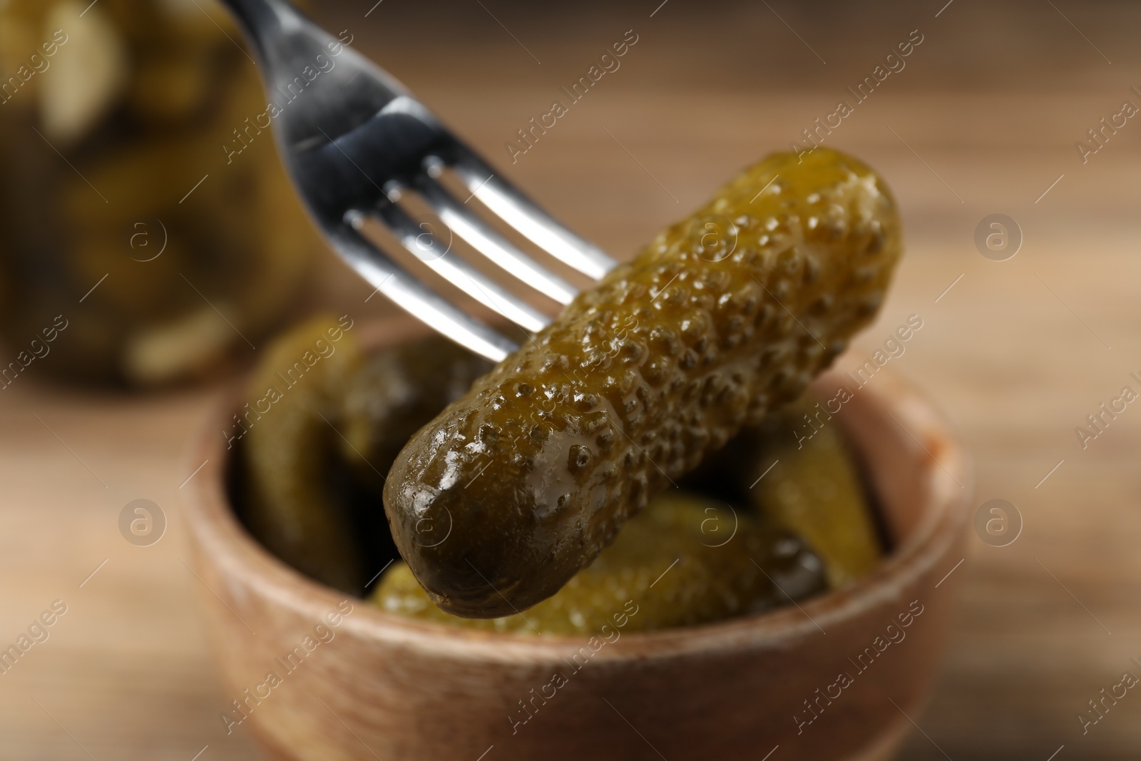 Photo of Eating tasty pickled cucumber at table, closeup