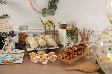 Photo of Beautiful cake and other treats on table in room. Baby shower party