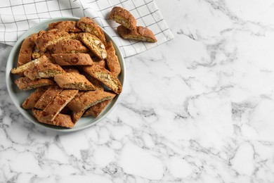 Photo of Traditional Italian almond biscuits (Cantucci) on white marble table, flat lay. Space for text
