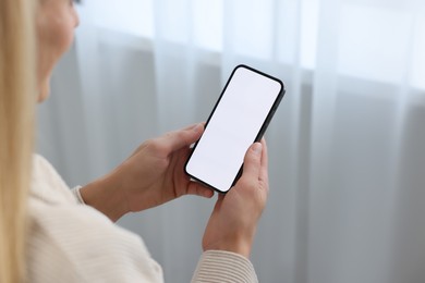 Photo of Woman using smartphone at home, closeup. Space for text