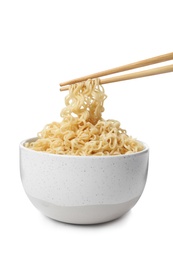 Photo of Chopsticks with tasty instant noodles over bowl isolated on white