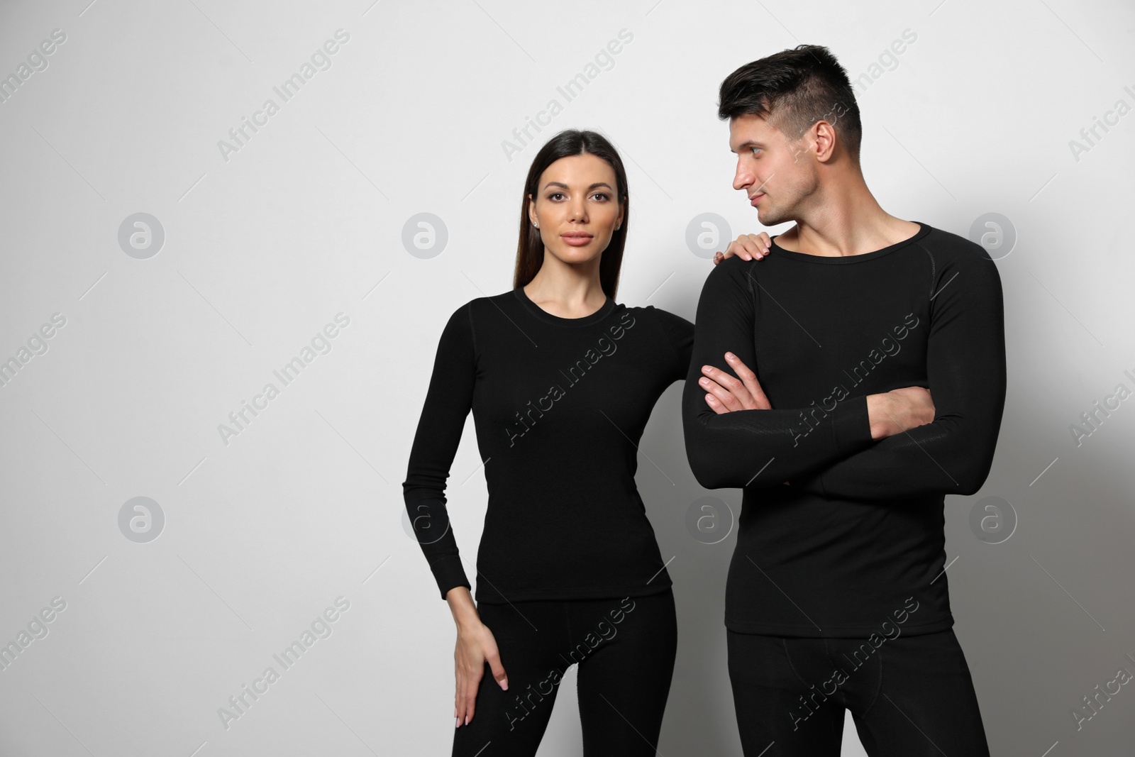 Photo of Couple wearing thermal underwear on light grey background. Space for text