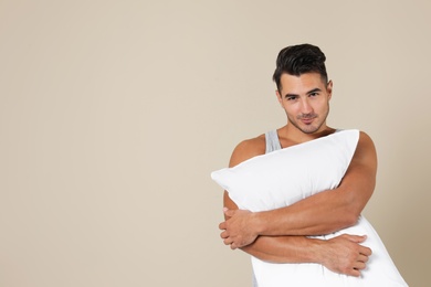 Photo of Young man with soft pillow on color background