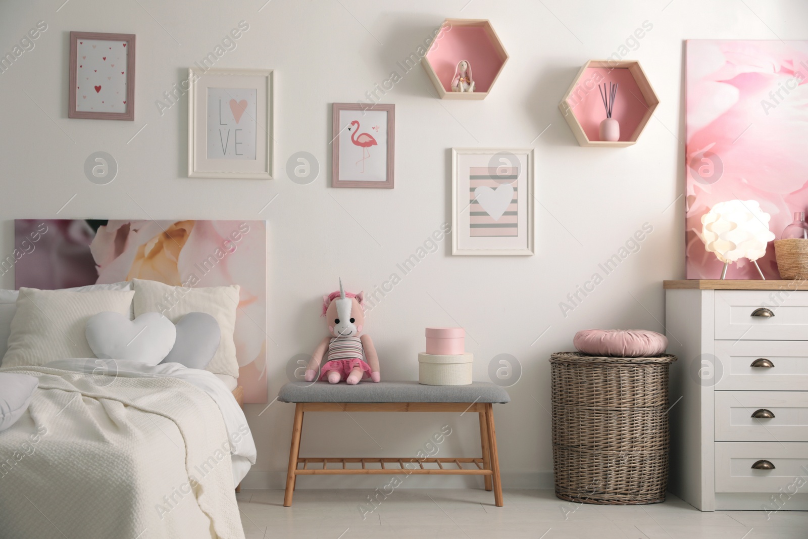 Photo of Stylish child's room interior with beautiful pictures and comfortable bed