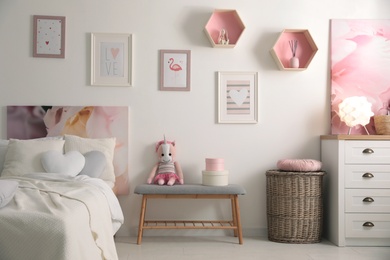 Photo of Stylish child's room interior with beautiful pictures and comfortable bed