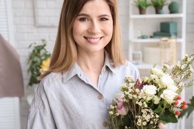 Photo of Female florist with beautiful bouquet at workplace