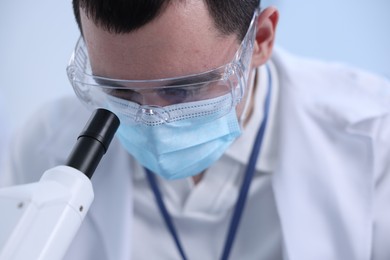 Scientist working with microscope in laboratory, closeup