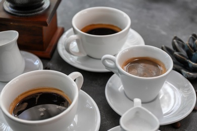 Cups of fresh aromatic coffee on grey background