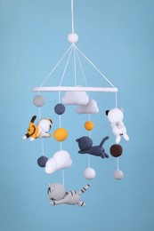 Photo of Cute baby crib mobile on light blue background