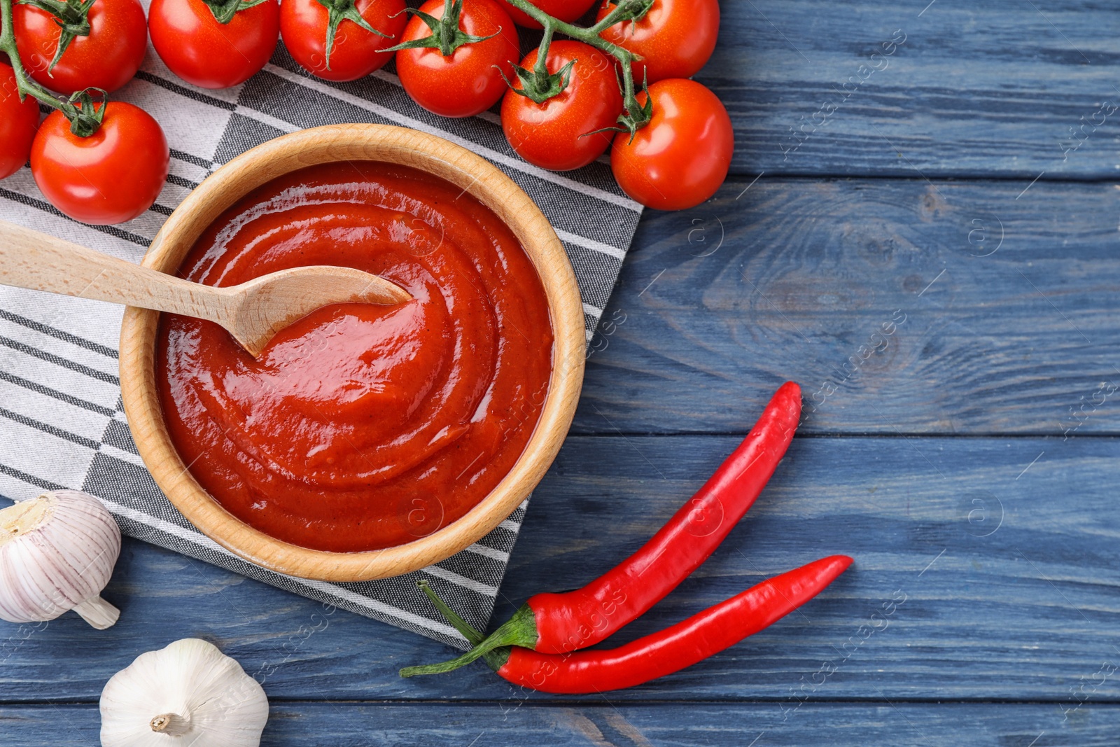 Photo of Flat lay composition with tomato sauce on blue wooden background