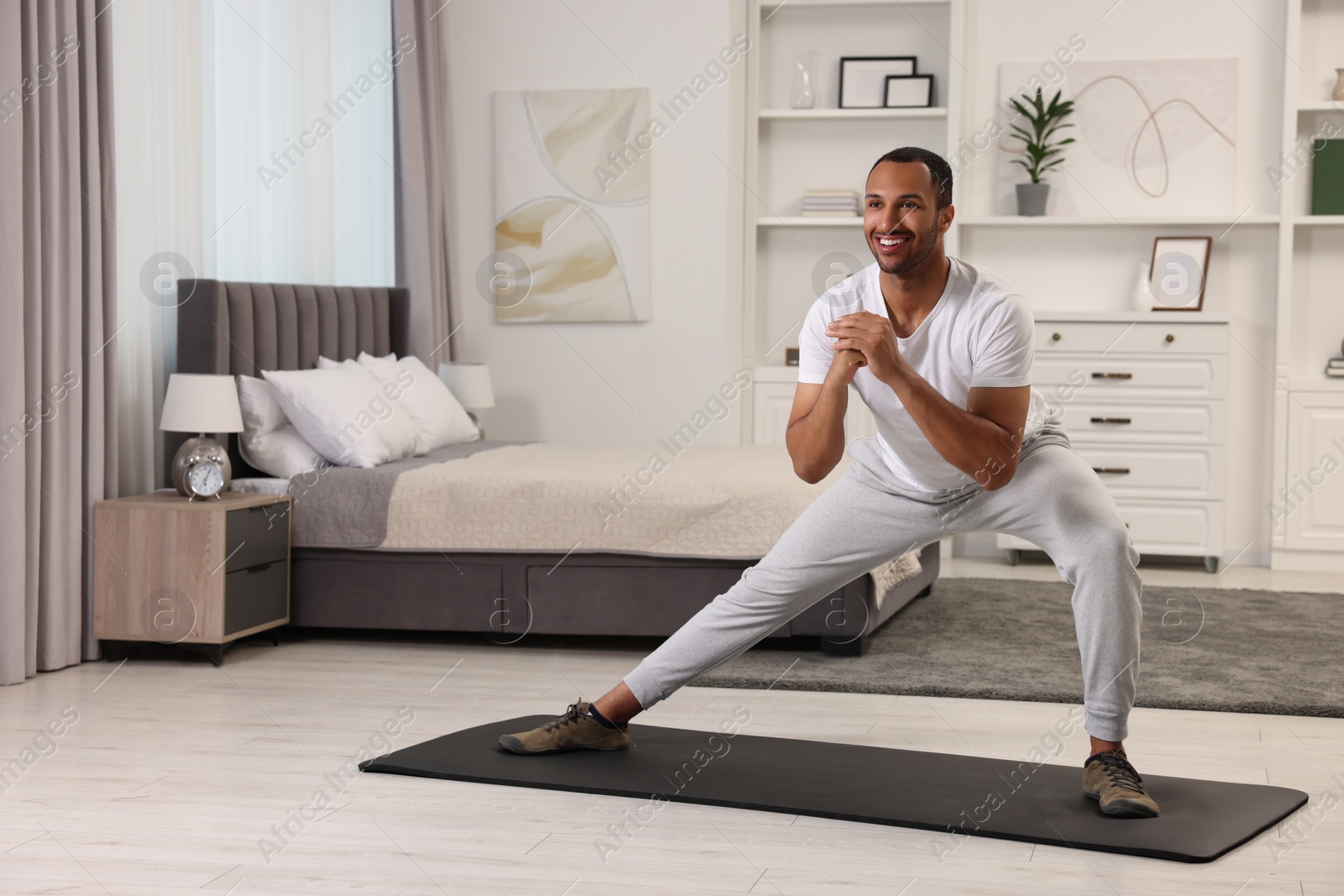 Photo of Man doing morning exercise on fitness mat at home