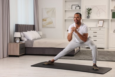 Man doing morning exercise on fitness mat at home